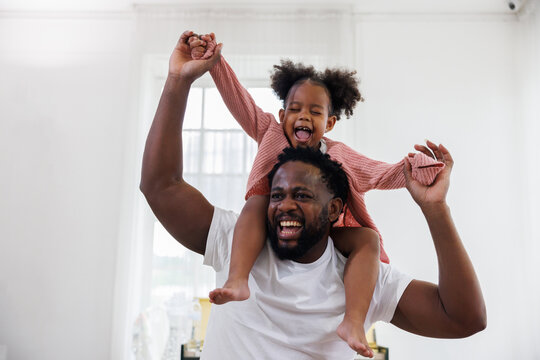 enjoy happy love black family african american father carrying daughter little african girl child smiling and having fun moments good time.  American father day concept.