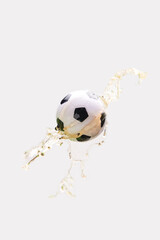 Soccer ball in beer splash on white background.
