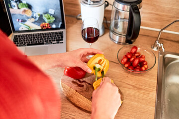 Close-up of the hands of a girl preparing a salad according to a video recipe. Cooking courses online. Video recipes and food blog