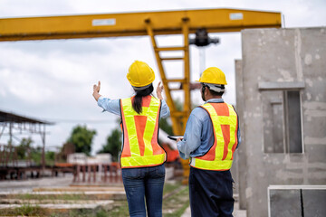 At construction site senior engineer and supervisor check overhead crane lift precast concrete slabs