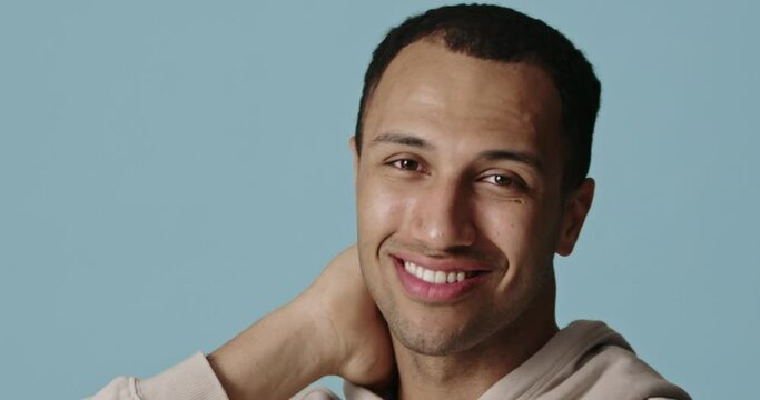 Laughing man touching head after beauty routine. Happy guy looking camera