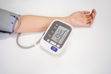 Woman check blood pressure monitor and heart rate monitor with digital pressure gauge with copy space on white background.