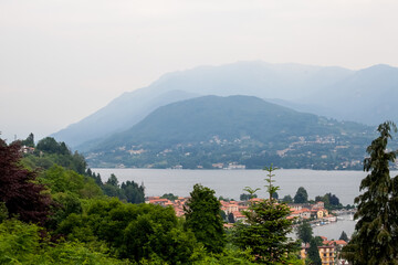 Fototapeta premium Mountain lake and city on green hills in Italy