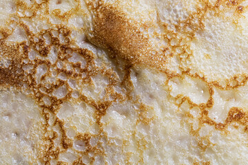 Pancake surface texture and pattern. Close-up of thin hot pancakes in a plate. Traditional rustic food. Graphic resource.