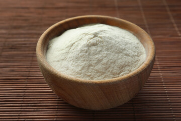 Bowl of agar-agar powder on bamboo mat, closeup