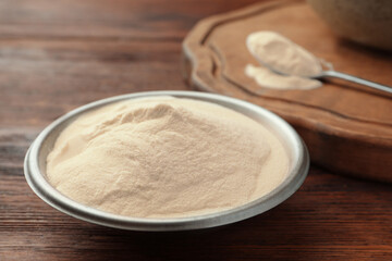Bowl of agar-agar powder on wooden table, closeup
