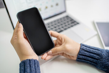A mockup of a blank mobile phone screen for a business man message at work. Cropped image of young woman holding blank screen smartphone.