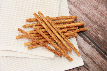 dry sesame bread sticks with small seeds for dietary nutrition, on a wooden background