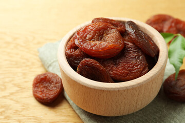 Bowl of tasty apricots on wooden table, closeup. Dried fruits