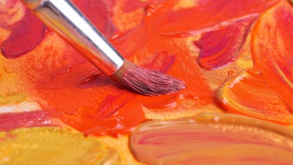 Brush on artist's palette with mixed paints, closeup