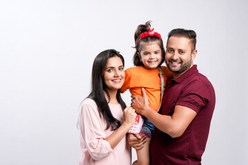 Happy indian couple with her daughter standing on white background.