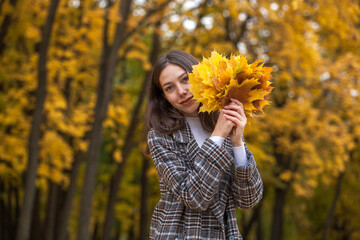 Young beautiful brown-haired girl in autumn park