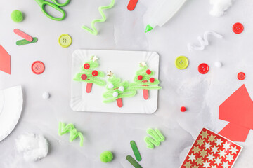 The child makes a greeting card Christmas paper collage. Made with his own hands. Children's art project craft for kids. Craft for children. Top view