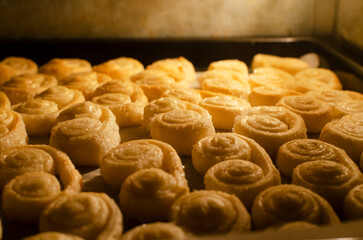 Cookies from puff pastry with sugar baking process in the oven. The concept of homemade baking. Horizontal orientation. Selective focus