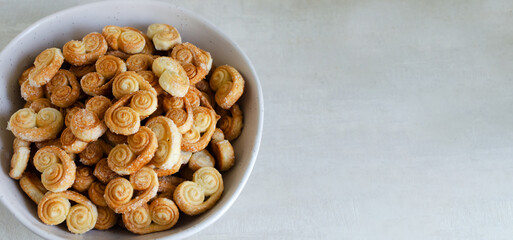 Puff pastry cookies with sugar in a large bowl. The concept of homemade baking. Top view. Copy space. Banner. Horizontal orientation. Selective focus