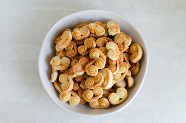 Puff pastry cookies with sugar in a large bowl. The concept of homemade baking. Top view. Horizontal orientation. Selective focus