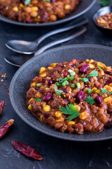 Shallow bowls of black been and corn chili, ready for eating. 