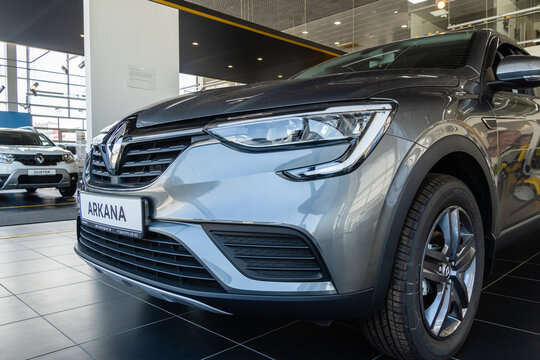SUV Renault Arkana in showroom of Renault dealership. Close-up of front grille with logo Renault and hood of car. View from left. Mega Adygea. Krasnodar, Russia - August 04, 2022
