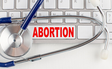 ABORTION text on keyboard with stethoscope , medical concept