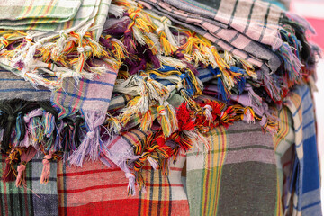 A stack of cotton plaid textiles in the street shop. Different colors. Turkey (Turkiye). Home design, household or textile manufacturing concept