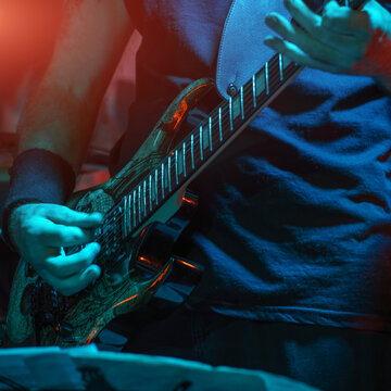 The guitarist plays on guitar. Hands of a Guitar player playing the guitar. Selective focus. Soft focus