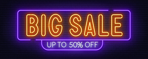 Big Sale neon sign on brick wall background.
