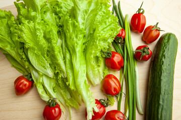 Salad leaves and tomatoes and green onion and cucumber, top view. Background from fresh vegetable for salad for poster, calendar, post, screensaver, wallpaper, card, banner, cover, website.