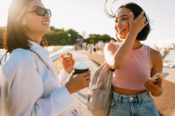 Two young beautiful stylish smiling happy asian girls