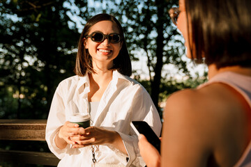Young beautiful smiling woman in glasses looking at her friend