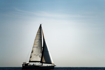 Profile of sailboat silhouette over white sky for text