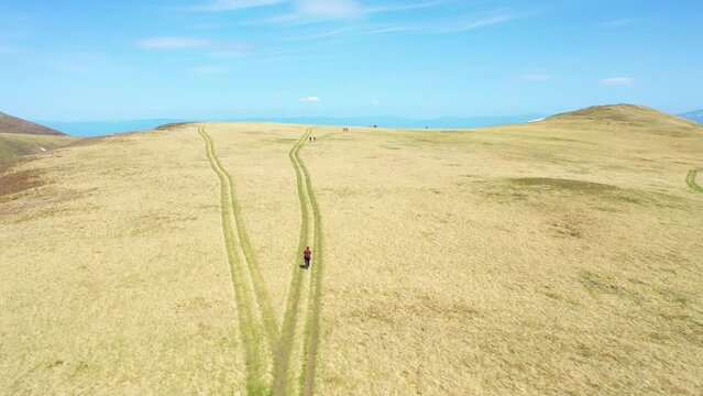 A beautiful plateau on a mountain with a road and hikers - leading lines example - 4k drone footage