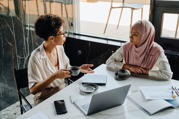 Middle-aged businesswoman and her female colleague working in office