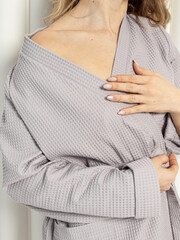 Woman in grey waffle bathrobe. Soft natural fabric
