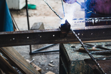Processing of metal. A man welds a metal with a welding machine, profession of welder, weld metal.