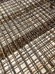 MELAKA, MALAYSIA -JULY 2, 2022: Steel reinforcement bars are arranged according to the structural engineer's design. The steels are tied together using a small steel wire.