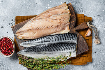 Cooking of fresh raw mackerel fillet fish on a cutting board. Gray background. Top view - obrazy, fototapety, plakaty