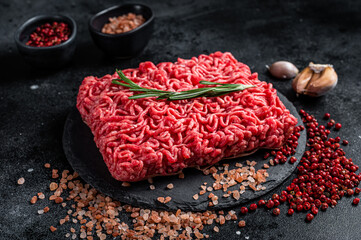 Uncooked beef veal Mince Meat, raw ground meat. Black background. Top view