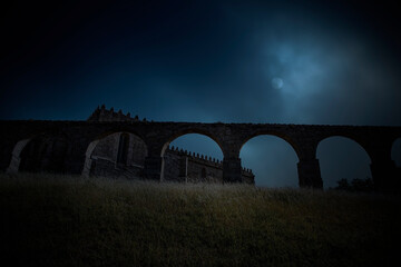 Medieval abbey in a foggy full moon night