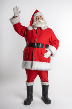Full length Christmas Santa Claus over a blank greeting card with his hand raised. With an invitation on a white background.