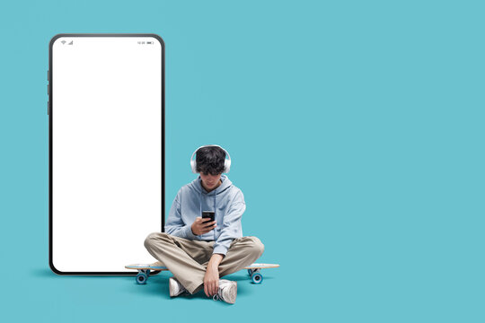 Teenage skater and big smartphone