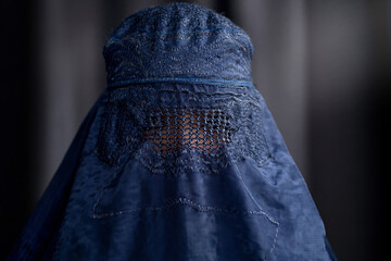 Closeup of Muslim woman in Burka or Burqa, tradition cloths in Afghanistan and West Pakistan, Muslim women wear a burqa covering their face and body - obrazy, fototapety, plakaty