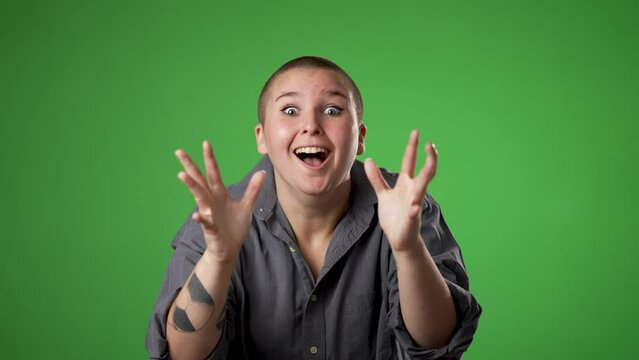 Slow motion in prayer begging about something making wish keep fingers crossed portrait of gender fluid non binary young woman 20s isolated on green screen background studio. 