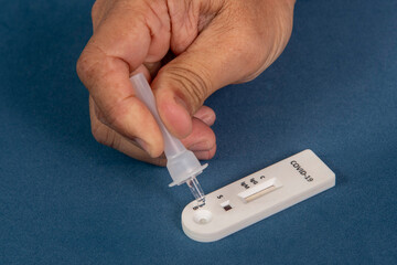 Covid-19 rapid test with person dripping the reagent