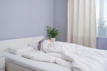 A bearded young man is sleeping in cozy bed. Happy to sleep. Healthy sleep of a man in a fresh white bed.
