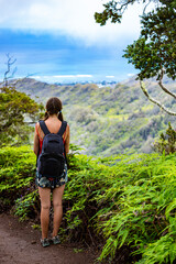 Naklejka premium hiker girl with backpack admires hawaii panorama from kuliouou ridge trail, hiking through mountains on oahu near honolulu