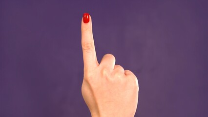 Countdown. Female hand counting 1 on purple background. Girl shows fist fist