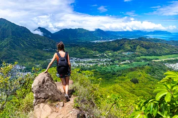 Fototapeten hiker girl stands at the top of olomana ridge trail admiring the panorama of oahu and hawaii mountains  famous three peaks on oahu, dangerous hiking on hawaii mountains, hawaii holidays © Jakub