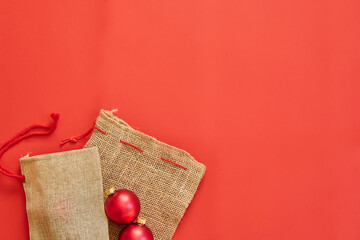 christmas jute bag with glass balls on red wallpaper