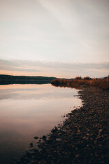 Riverbank in sunset and totally reflective water