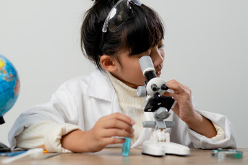 Fototapeta premium education, science, chemistry and children concept - kids or students with test tube making experiment at school laboratory
